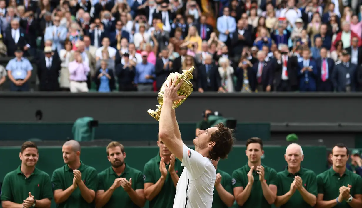 Andy Murray mengangkat trofi Wimbledon usai mengalahkan petenis Kanada,  Milos Raonic pada tunggal putra Wimbledon Championships 2016 di The All England Lawn Tennis Club,  Wimbledon, London, (10/7/2016). (AFP/Glyn Kirk)