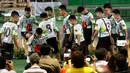 12 anak laki-laki dan pelatih sepak bola mereka, yang diselamatkan dari gua banjir di Thailand, memasuki ruang konferensi pers sambil menendang bola di Chiang Rai, Rabu (18/7). Mereka muncul di depan umum untuk pertama kalinya (AP/Vincent Thian)
