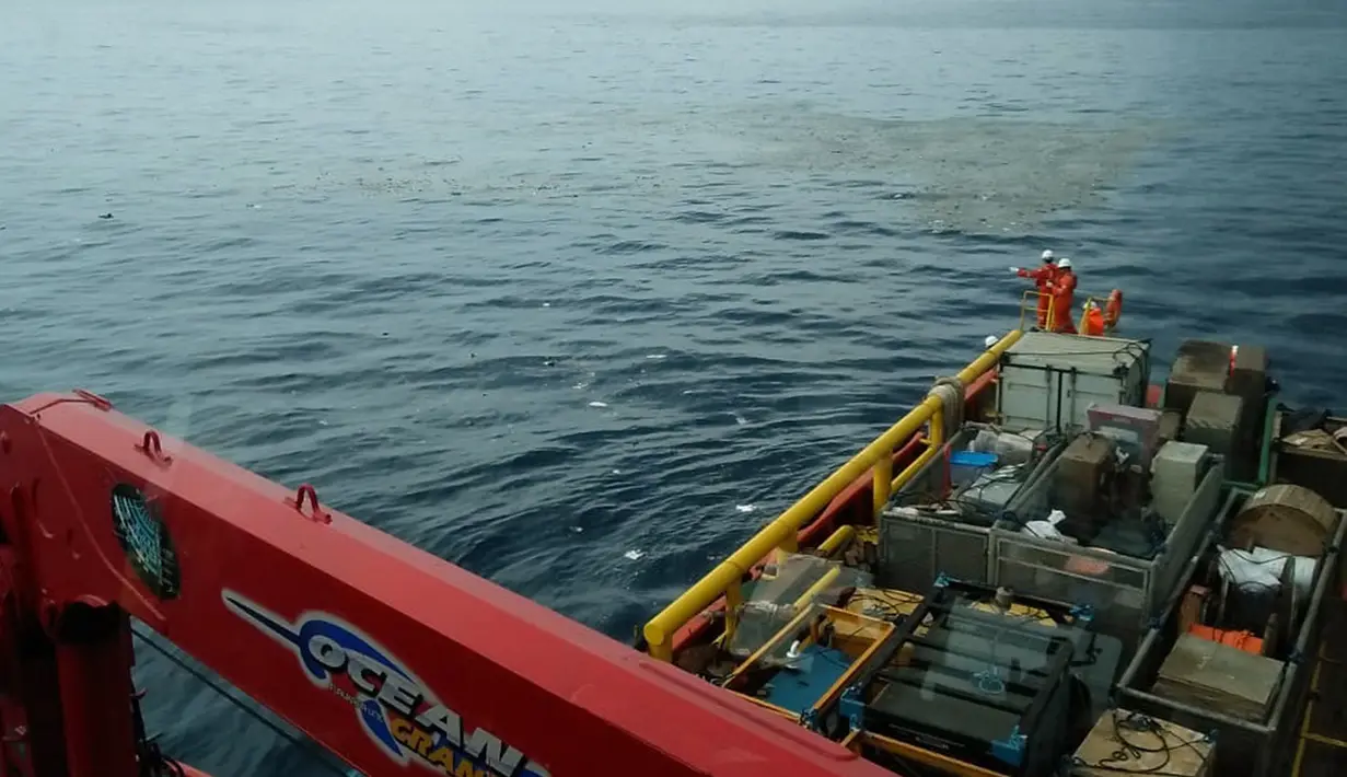 Awak kapal Pertamina mengamati serpihan pesawat Lion Air bernomor penerbangan JT610 rute Jakarta-Pangkalpinang yang jatuh di laut utara Karawang, Jawa Barat, Senin (29/10). (HO/NATIONAL DISASTER MITIGATION AGENCY/PERTAMINA HULU ENERGY / AFP)