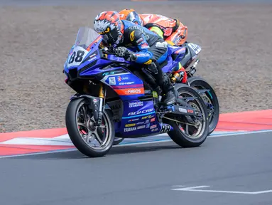 Pembalap Yamaha Racing Indonesia, Candra Hermawan (kiri) memacu motornya bersaing dengan pembalap lain saat Race 2 AP250 Asia Road Racing Championship (ARRC) Mandalika 2025 di Sirkuit Internasional Pertamina Mandalika, Lombok, NTB, Minggu (31/08/2025). (Bola.com/Bagaskara Lazuardi)