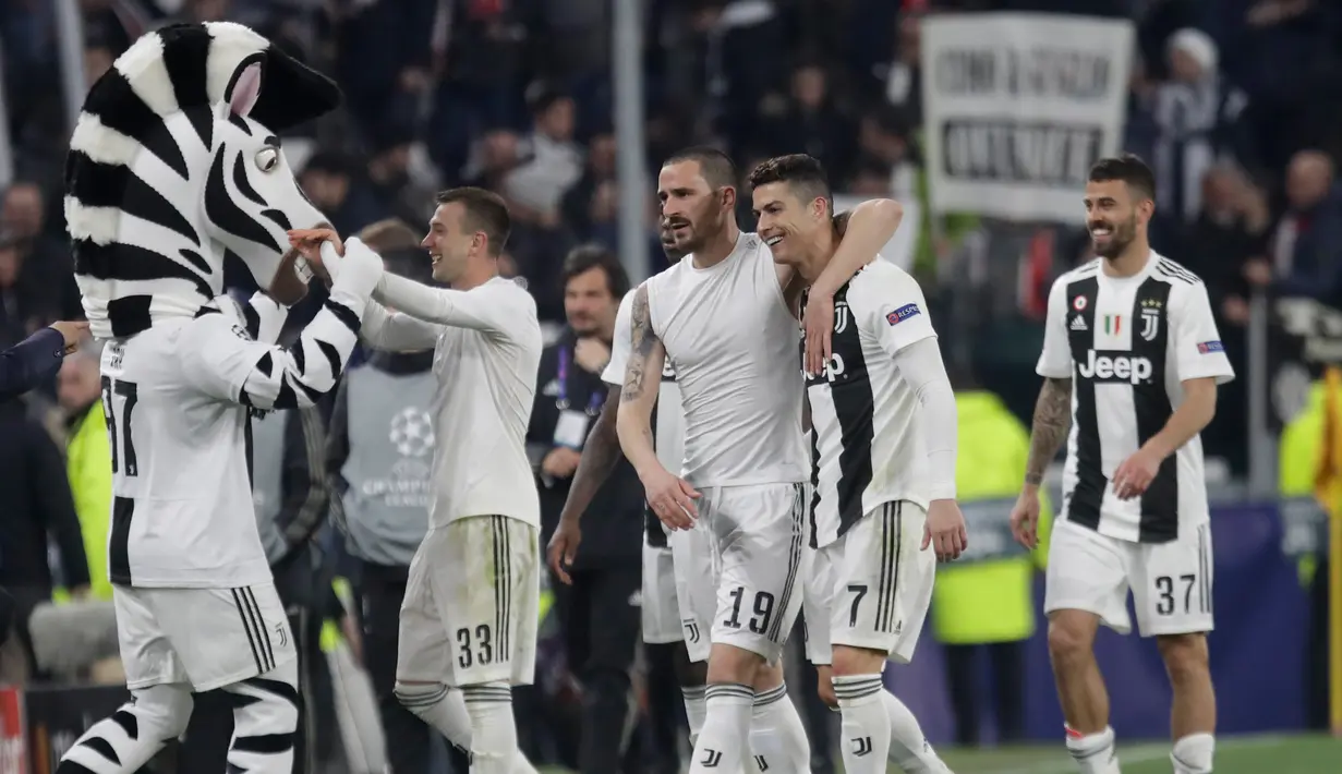 Bek Juventus Leonardo Bonucci (tengah) merangkul Cristiano Ronaldo usai mereka mengalahkan Atletico Madrid pada leg kedua babak 16 besar Liga Champions di Allianz Stadium, Turin, Selasa (12/3). Atletico tersingkir dari Liga Champions.(AP Photo/Luca Bruno)