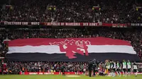 Fans MU di Old Trafford&nbsp;membentangkan bendera Manchester United saat menjamu&nbsp;Liverpool pada perempat final Piala FA, Minggu (17/3/2024) waktu setempat.&nbsp;(AP Photo/Dave Thompson)