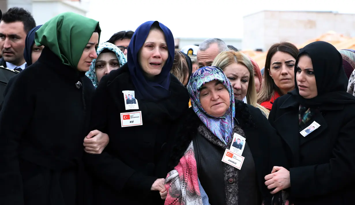 Anggota keluarga berkabung saat salat pemakaman untuk tentara Turki pertama yang tewas dalam operasi 'Ranting Zaitun' di daerah Kurdi Suriah, Ankara, Turki, Selasa (23/1). (Foto AP/Burhan Ozbilici)