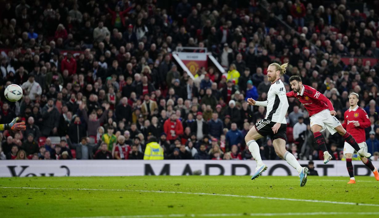 Pemain MU, Bruno Fernandes (kanan), menendang bola ke gawang Fulham yang membuahkan gol ketiga bagi Setan Merah dalam babak perempat final Piala FA 2022/2023, Minggu (19/3/2023) malam WIB. (AP Photo/Jon Super)