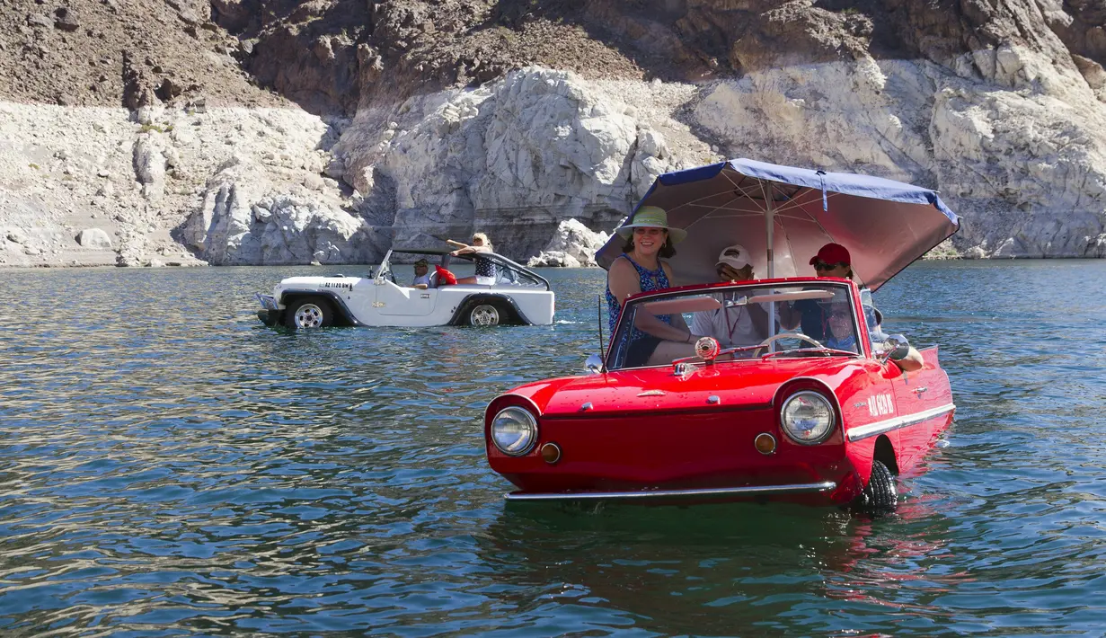 Mobil amfibi Panther WaterCar (kiri), yang dikemudikan Bob Davis dan Amphicar 1963, dikemudikan Rob Vondracek saat festival Las Vegas Amphicar Swim di Danau Mead, Nevada, Jumat (9/10). (REUTERS/Steve Marcus)