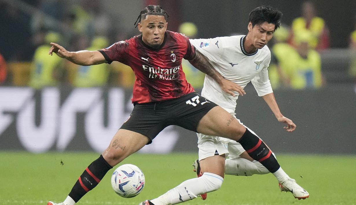 Pemain AC Milan, Noah Okafor, berebut bola dengan pemain Lazio, Daichi Kamada, pada giornata ketujuh Serie A 2023/2024 di Stadion San Siro, Mingggu (1/10/2023). AC Milan berhasil unggul terlebih dahulu melalui gol Christian Pulisic sementara Noah Okafor mengunci kemenangan Rossoneri di akhir babak kedua. (AP Photo/Luca Bruno)