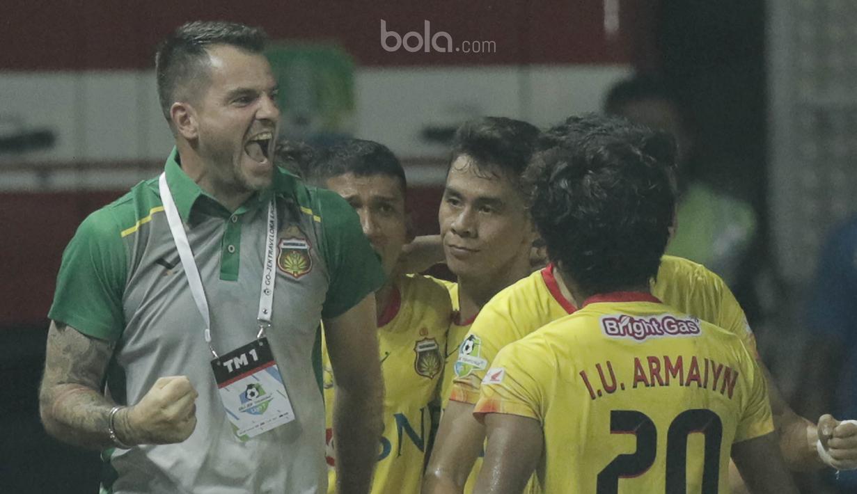 Pelatih Bhayangkara FC, Simon Mc Menemy, merayakan gol yang dicetak oleh Alsan Putra ke gawang Madura United pada lanjutan liga 1 di Stadion Patriot, Bekasi, kamis (13/7/2017). Bhayangkara FC menang 2-1 atas Madura United. (Bola.com/M Iqbal Ichsan)