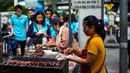 Seorang wanita memasak sate di gerobaknya di samping jalan di Bangkok, Thailand (20/9).  Makanan Thailand juga banyak dipengaruhi oleh kultur kuliner Cina, terutama Suku Han. (AFP Photo/Jewel Samad)