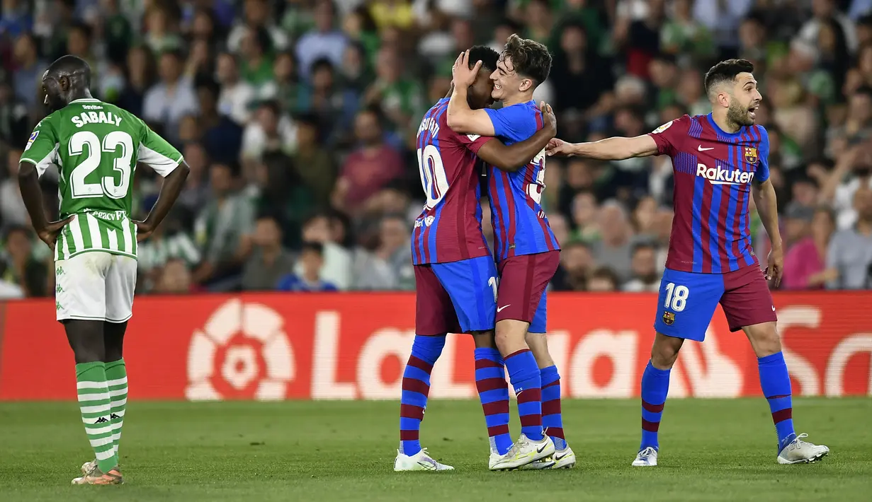 <p>Pemain Barcelona Ansu Fati (tengah) merayakan dengan rekan setimnya setelah mencetak gol ke gawang Real Betis pada pertandingan sepak bola La Liga Spanyol di Stadion Benito Villamarin, Seville, Spanyol, 7 Mei 2022. Barcelona menang 2-1. (AP Photo/Jose Breton)</p>