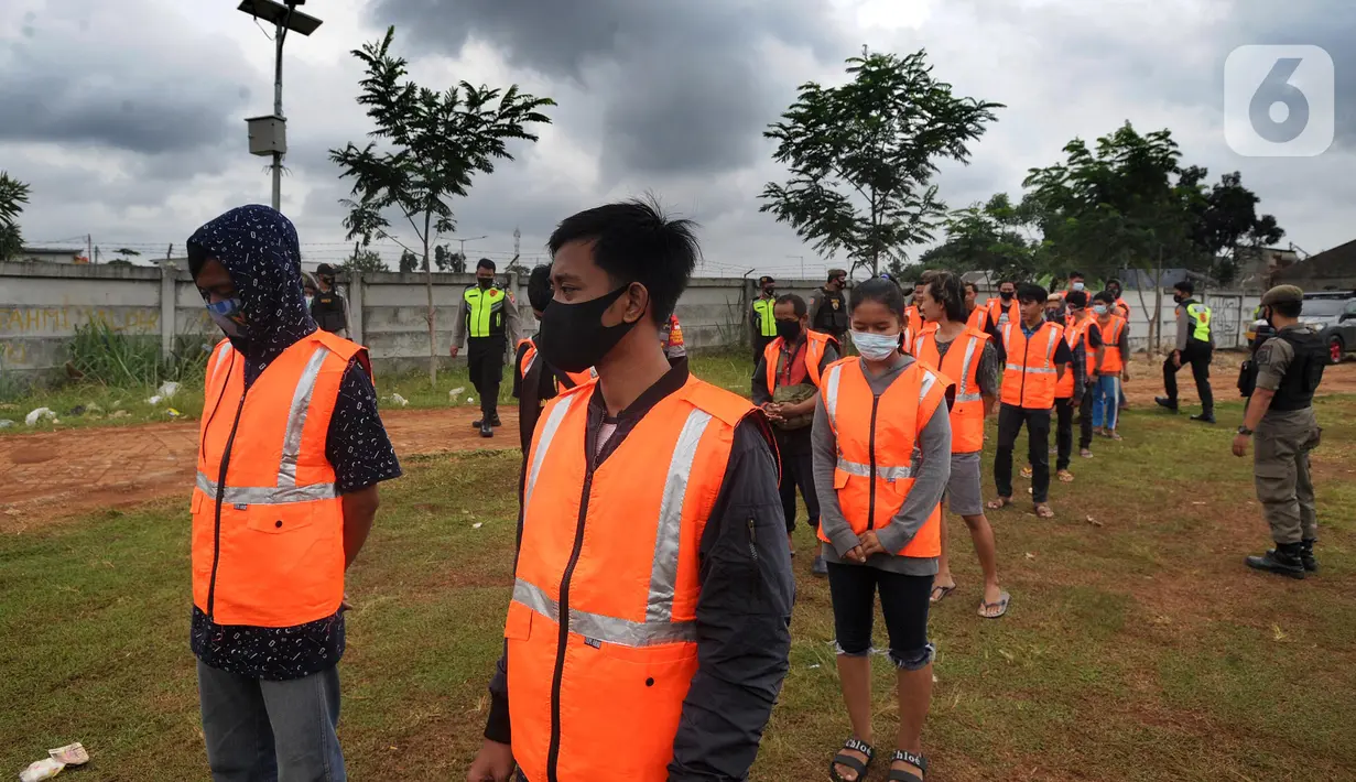 Sejumlah pelanggar PSBB bersiap doa di makam korban Covid-19 di TPU Jombang, Tangerang Selatan, Senin (18/1/2020). 17 pelanggar PSBB tersebut dihukum untuk berdoa di makam korban Covid-19. (merdeka.com/Arie Basuki)