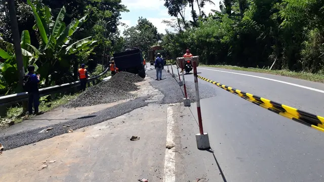 Petugas bina marga menguruk jalan yang ambles dengan LPA. (Foto: Liputan6.com/Muhamad Ridlo)