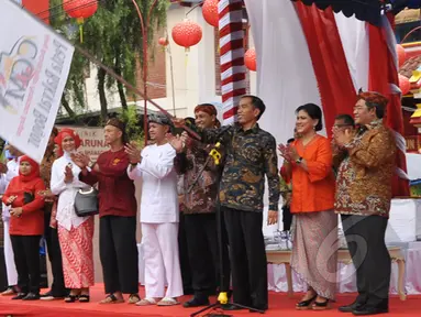 Sambil mengayunkan bendera, Presiden Jokowi memberi tanda dimulainya acara perayaan Cap Go Meh di Kota Bogor, Jawa Barat, Kamis (5/3/2015). (Liputan6.com/Faizal Fanani)