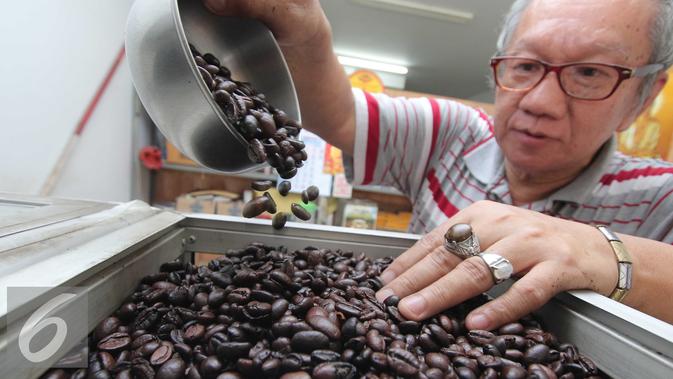 Pedagang memasukan biji kopi asal Lampung kedalam kotak di Jakarta, Rabu (10/2). Volume ekspor biji kopi Lampung kian terpuruk. Januari lalu, Lampung hanya mengapalkan 8.418 ton biji kopi, dan mengantongi devisa US$ 14 juta. (Liputan6.com/Angga Yuniar)