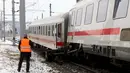 Seorang petugas regu penyelamat berdiri di lokasi tabrakan yang melibatkan dua kereta penumpang dekat stasiun di Niklasdorf, Austria, Senin (12/2). Sejauh ini 17 orang harus mendapatkan perawatan medis akibat luka serius yang diderita. (AP/Ronald Zak)