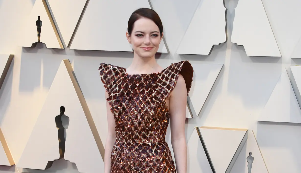 Aktris Emma Stone berpose di karpet merah menghadiri perhelatan Piala Oscar 2019 di Teater Dolby di Los Angeles, AS (24/2). Emma Stone tampil cantik mengenakan gaun emas seperti sarang lebah Louis Vuitton. (AFP Photo/Mark Ralston)