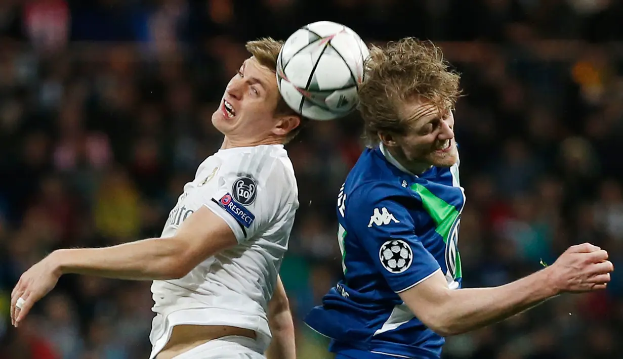 Gelandang Real Madrid, Toni Kroos (kiri) berebut bola dengan penyerang Wolfsburg, Andre Schurrle di leg kedua liga Champions di Santiago Bernabeu, Spanyol (13/4). Madrid menang atas Wolfsburg dengan skor 3-0. (Reuters/Sergio Perez)