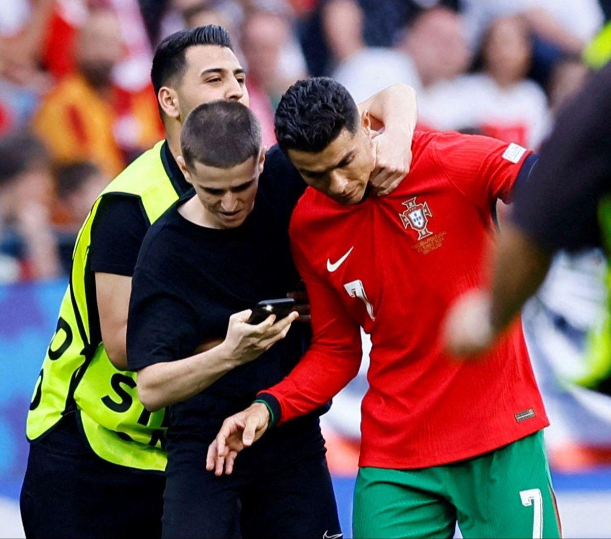 Namun saat laga Piala Eropa 2024 antara Portugal Vs Turki, pemain Al-Nassr itu mendapat serbuan dari fans fanatic yang memburu berfoto dengannya.<br>Para penggemar itu sampai nekat menerobos lapangan demi bisa berfoto bersama CR7, berikut aksi penggemar y