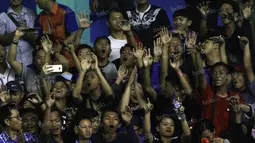 Gregoria Mariska (kiri), dan Tiara Rosalia Nuraidah, bersemangat mendukung rekannya melawan DKI Jakarta dengan bernyanyi bersama suporter saat final beregu bulutangkis PON XIX di GOR Bima, Cirebon, Jumat (23/9/2016). (Bola.com/Arief Bagus)