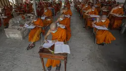 Sejumlah Biksu Buddha memakai masker untuk membantu melindungi diri dari virus corona, mengikuti tes bahasa Pali liturgi di Wat Molilokayaram di Bangkok, Thailand, Kamis (20/1/2022). (AP Photo/Sakchai Lalit)