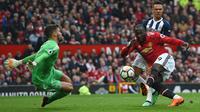 Striker Manchester United (MU) Romelu Lukaku (kanan) melepas tembakan yang dihentikan kiper West Bromwich Albion Ben Foster pada laga di Old Trafford, Minggu (15/4/2018). (AFP/Paul Ellis)