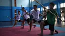 Empat siswa berlatih Krabi Krabong di sekolah Thonburee Woratapeepalarak, Thonburi, Bangkok (8/7/2019). Krabi Krabong merupakan seni bela diri Thailand yang dipersenjatai pisau dan perisai kayu yang terabaikan. (AFP Photo/Lillian Suwanrumpha)