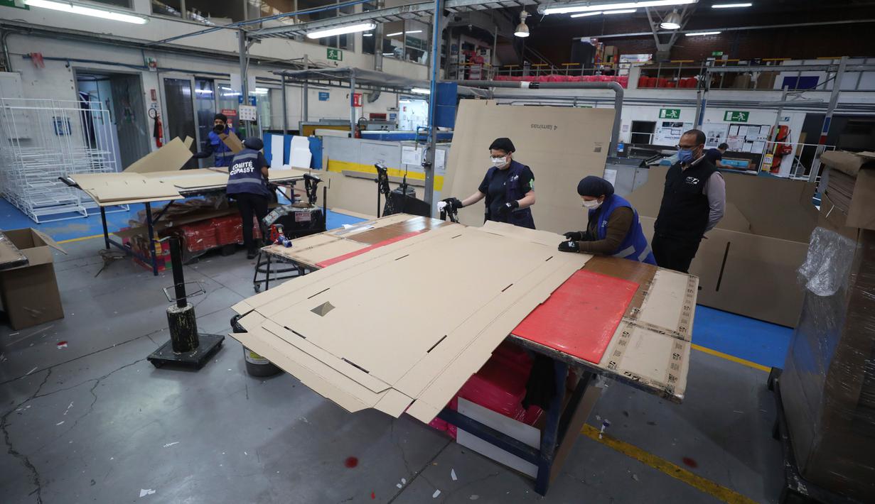 Pekerja sebuah perusahaan mendesain kardus yang dapat berfungsi sebagai tempat tidur rumah sakit dan peti mati untuk pasien COVID-19 di Bogota, Kolombia, Jumat (8/5/2020). Perusahaan ini menanggapi kekurangan tempat tidur dan peti mati selama pandemi virus corona.  (AP/Fernando Vergara)