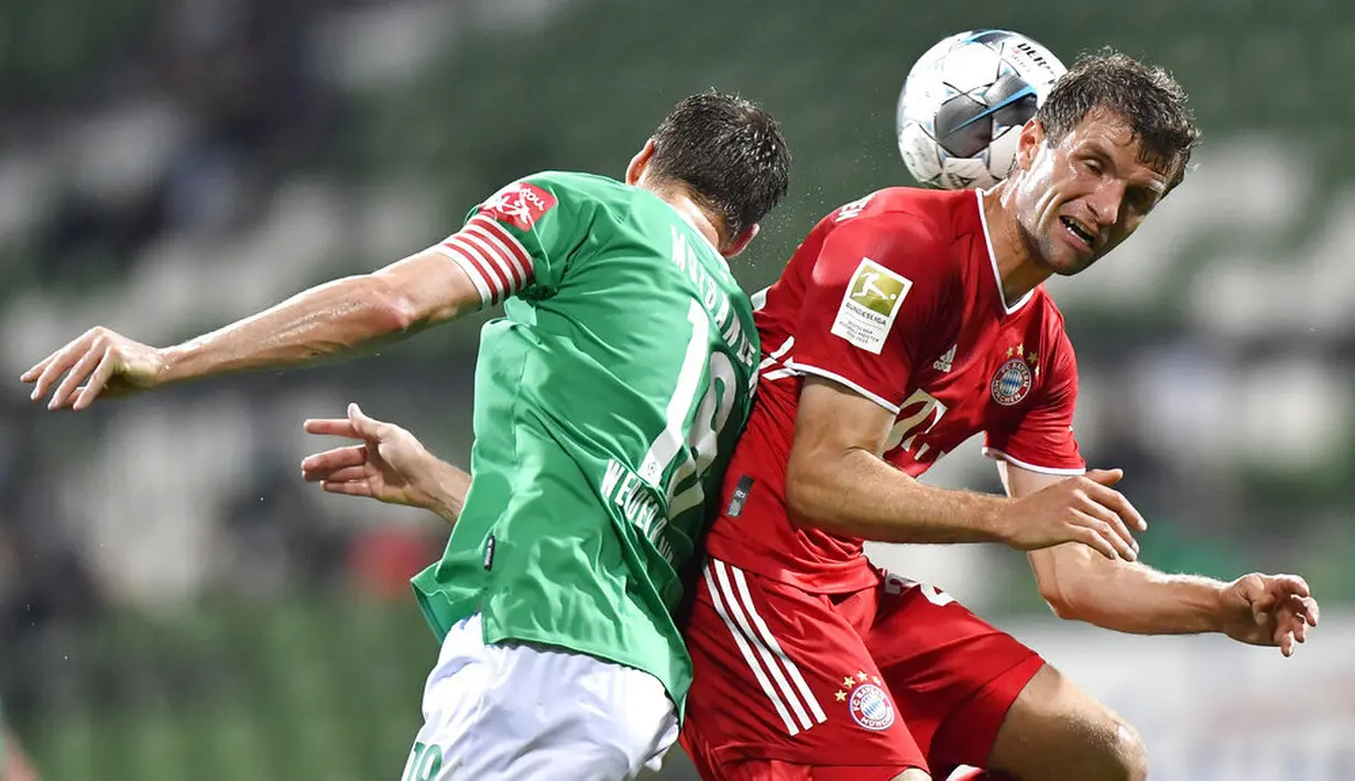 Penyerang Bayern Munchen, Thomas Mueller, duel udara dengan pemain Werder Bremen pada laga Bundesliga di Weserstadion, Bremen, Selasa (16/6/2020). Bayern Munchen menang dengan skor 1-0 atas Werder Bremen. (AP/Martin Meissner)