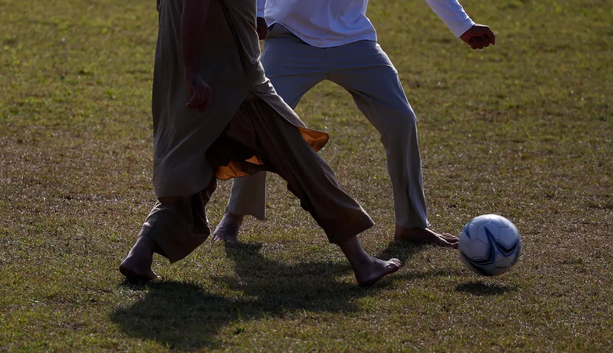 Pengungsi Afghanistan bermain sepak bola di taman bermain Institut Pengembangan Sumber Daya Manusia Nasional di Jincheon, Korea Selatan (13/10/2021). Sekitar 390 warga Afghanistan diterbangkan dari Kabul ke Korea Selatan. (AFP/Pool/Jeon Heon-kyun)