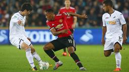 Striker Manchester United, Anthony Martial, berusaha melewati pemain Swansea City pada laga Piala Liga Inggris di Stadion Liberty, Swansea, Selasa (24/10/2017). Manchester United menang 2-0 atas Swansea City. (AFP/Geoff Caddick)