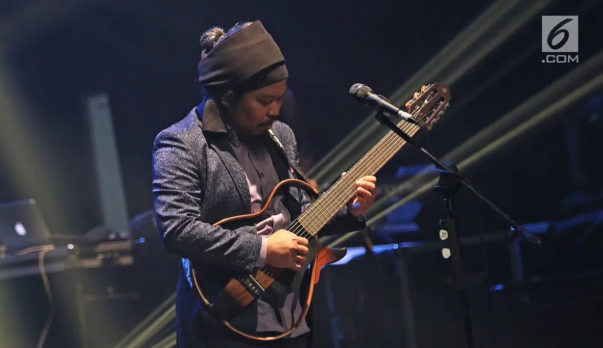 Aksi panggung vokalis Payung Teduh, Is saat tampil dalam konser BBM x Liztomania vol.3 di Gedung Kesenian Jakarta, Selasa (14/11). Konser Musik Tanah Air Vol.3 ini bertajuk Payung Teduh "Catra Adhum". (Liputan6.com/Herman Zakharia)