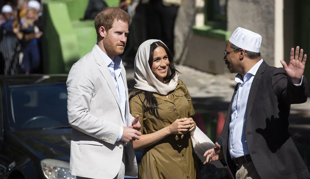Duchess of Sussex Meghan Markle bersama suaminya, Pangeran Harry berbincang dengan seorang pria saat mengunjungi Masjid Auwal, Cape Town, Afrika Selatan (24/9/2019). (AFP Photo/David Harrison)