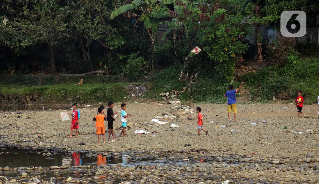 Anak-anak bermain layang-layang di area Bendungan Katulampa, Kota Bogor, Jawa Barat, Senin (3/8/2020). Debit air sungai Ciliwung di Bendung Katulampa yang mengalami penyusutan sejak satu bulan terakhir dimanfaatkan anak-anak untuk bermain air dan layangan. (Liputan6.com/Helmi Fithriansyah)