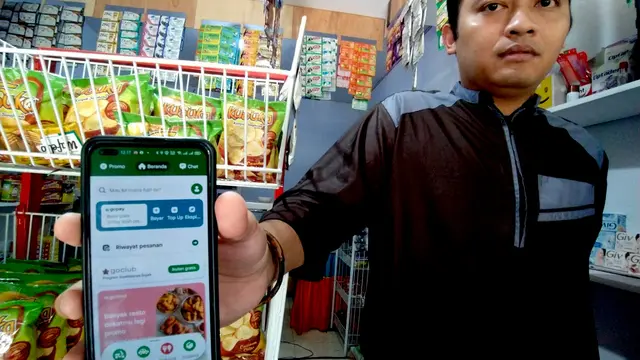 Rezcky Wartabone pelaku UKM saat memperlihatkan aplikasi gojek yang digunakan untuk menunjang usahanya (Foto: Arfandi Ibrahim/Liputan6.com)