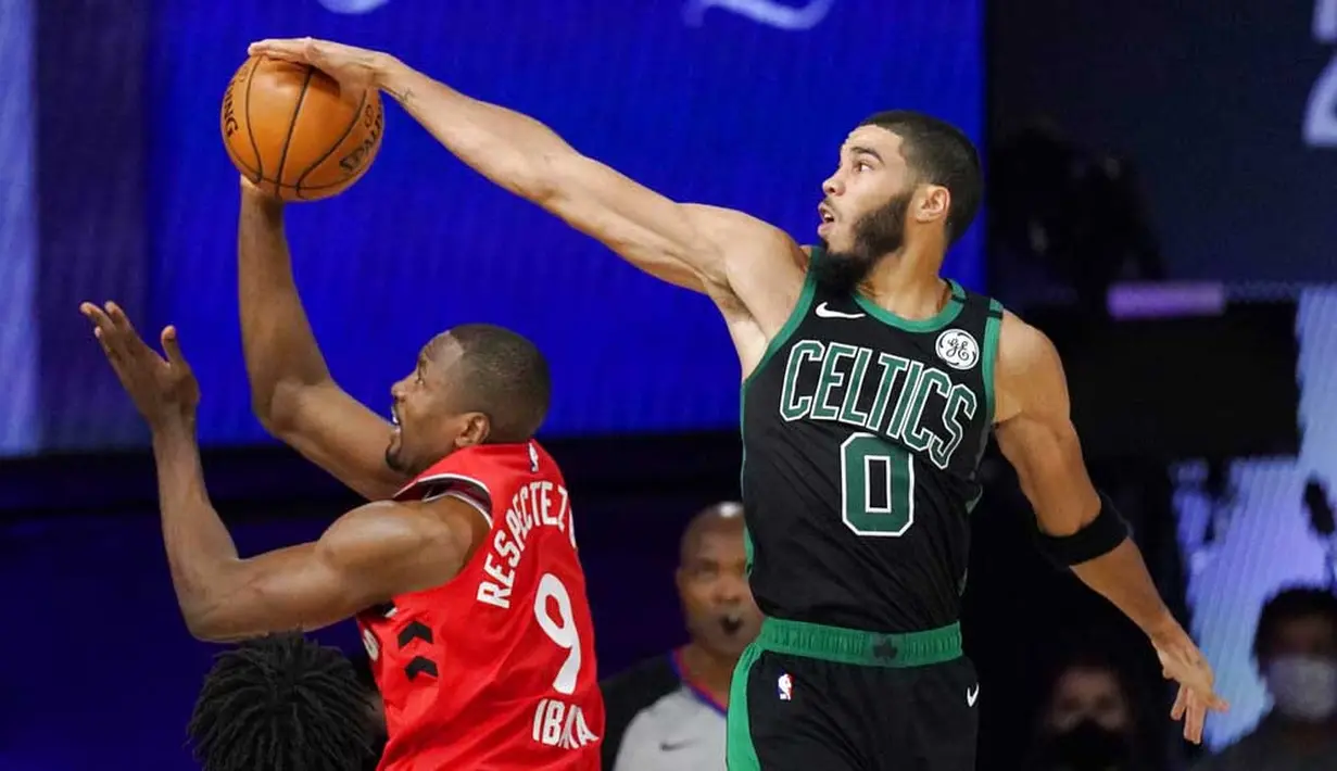 Pebasket Boston Celtics, Jayson Tatum, berebut bola dengan pebasket Toronto Raptors, Serge Ibaka, pada laga NBA di Lake Buena Vista, Senin (7/9/2020). Boston Celtics menang telak 111-89 atas Toronto Raptors. (AP/Mark J. Terrill)