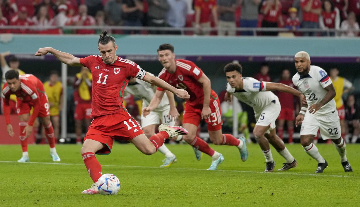 Gareth Bale. Striker Timnas Iran berusia 30 tahun ini sukses membuat satu gol lewat eksekusi penalti di Piala Dunia 2022 pada matchday pertama Grup B menghadapi Timnas Amerika Serikat (21/11/2022) yang berkesudahan imbang 1-1. Penalti terjadi pada menit ke-82 saat Timnas Wales tengah ketinggalan 0-1. (AP/Darko Vojinovic)