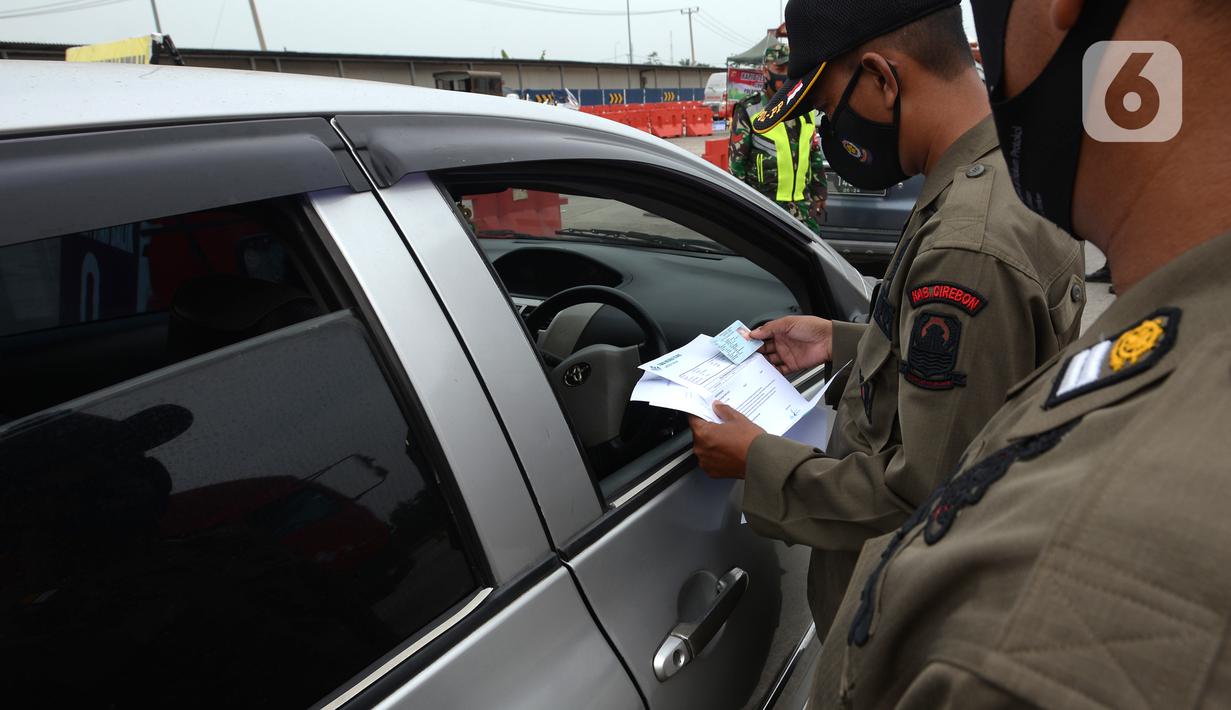 Petugas memeriksa kendaraan di Gerbang Tol Palimanan, Jakarta, Jumat, (7/5/2021). Gerbang Tol Palimanan sepi karena adanya kebijakan larangan mudik Lebaran pada tanggal 6-17 Mei 2021 untuk memutus penyebaran COVID-19. (merdeka.com/Imam Buhori)