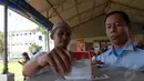 Petugas LP Cipinang tampak mendampingi seorang napi yang memasukkan kertas ke dalam kotak suara (Liputan6.com/ Miftahul Hayat).