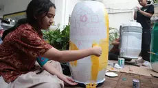 Sejumlah siswa komunitas perkusi Labsky Kebayoran "Dungtakravara" mengecat alat musik berbahan daur ulang di SMA Labschool Kebayoran, Jakarta Selatan, Kamis (23/7/2026). Drum plastik bekas, galon air mineral, diolah menjadi alat musik dan dekorasi panggung untuk drama musikal Skylite serta pentas seni Skyavenue 2026. (KLY/ Budy Santoso)