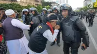 Peserta aksi mencium tangan Polisi dari kesatuan Brimob saat gelar doa bersama di depan kantor Bawaslu, Jakarta, Jumat (24/5/2019). Mereka datang untuk mendoakan para demonstran yang meninggal saat aksi 21-22 Mei, pasca hasil penghitungan suara Pemilu 2019. (Liputan6.com/Herman Zakharia)