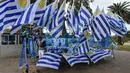 Pedagang menjual bendera dan merchandise Uruguay di Montevideo (4/7). Uruguay dan Prancis akan bertanding pada babak 8 besar Piala Dunia 2018 di Nizhny Novgorod Stadium, Rusia. AFP Photo/Miguel Rojo)