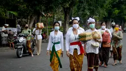 Umat Hindu tiba untuk merayakan Hari Raya Galungan di Pura Jagat Natha di Denpasar, di pulau Bali (16/9/2020). Galungan dirayakan umat Hindu di Bali sebagai hari kemenangan Dharma (Kebaikan) melawan Adharma (Keburukan). (AFP Photo/Sonny Tumbelaka)