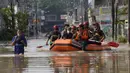 Warga duduk dalam perahu karet saat mereka mengungsi ke tempat yang lebih tinggi selama banjir di Bekasi, Jawa Barat, Kamis (17/2/2022). Hujan deras yang dikombinasikan dengan perencanaan pembuangan limbah kota yang buruk sering menyebabkan banjir besar. (AP Photo/Achmad Ibrahim)