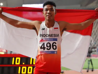 Sprinter Indonesia, Lalu Muhammad Zohri mengibarkan bendera Merah Putih seusai mengikuti kategori 100 meter dalam semifinal Kejuaraan Atletik Asia di Doha, Qatar, Senin (22/4). Lalu Muhammad Zohri sukses menggondol medali perak setelah membukukan catatan waktu 10,13 detik. (AP/Vincent Thian)