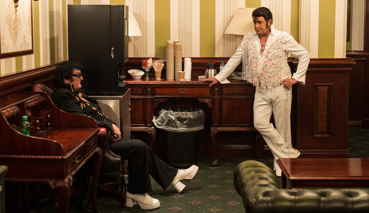 Artis Scott Chaple (kiri) dan Lee Aaron King berbincang di belakang panggung sebelum tampil dalam pembukaan 'Perayaan Elvis 2018' di Blackpool Winter Gardens, Barat Laut Inggris, Jumat (29/6). Festival digelar selama tiga hari. (Oli SCARFF/AFP)