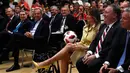 Ibu Negara AS, Melania Trump memegang bola selama konferensi pers bersama Presiden AS Donald Trump dan Presiden Rusia Vladimir Putin di Helsinki, Finlandia, Senin (16/7). Bola berwarna putih-merah itu diberikan oleh Putin. (AP/Pablo Martinez Monsivais)