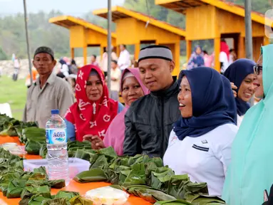 Warga melihat bungkus nasi kuning selama Gebyar Safar 1441 H di Desa Pangi, Kecamatan Suwawa Timur, Kabupaten Bone Bolango (Bonebol), Rabu (23/10/2019). Sebanyak 5.000 bungkus nasi kuning disajikan dalam perayaan yang turut dihadiri Bupati Bone Bolango, Hamim Pou, itu. (Liputan6.com/Arfandi Ibrahim)