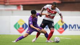 Pemain Madura United, Hugo Gomes "Jaja" (kanan) berebut bola dengan pemain Persik Kediri, Krisna Bayu Otto dalam laga pekan ke-13 BRI Liga 1 2021/2022 di Stadion Moch. Soebroto, Magelang, Rabu (24/11/2021). (Bola.com/Bagaskara Lazuardi)