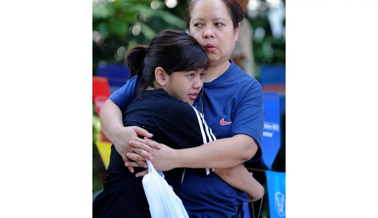 Seorang anak perempuan terlihat terus memeluk ibunya saat perayaan Hari Ibu yang diadakan di sebuah taman di pinggiran kota Manila, (11/5/2014). (AFP PHOTO/Jay Directo)