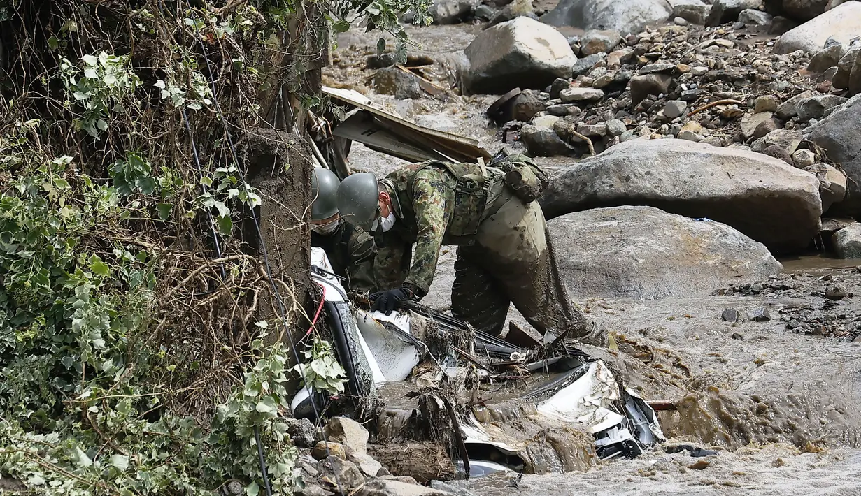 Tim penyelamat melanjutkan operasi pencarian di lokasi tanah longsor di Izusan di Atami, prefektur Shizuoka, barat daya Tokyo, Senin (5/7/2021). Bencana tanah longsor dipicu oleh hujan lebat tersebut menewaskan dua orang. (Kyodo News via AP)