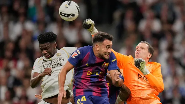 Kiper Barcelona, Wojciech Szczesny, meninju bola melewati Aurelien Tchouameni dari Real Madrid